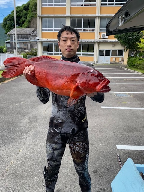 代表・田中祐貴 ─ 素潜り魚突きで獲ったアカハタを持つ